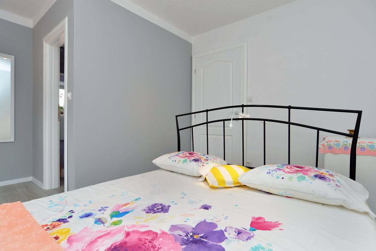 A bedroom with a bed, a door, and a window.