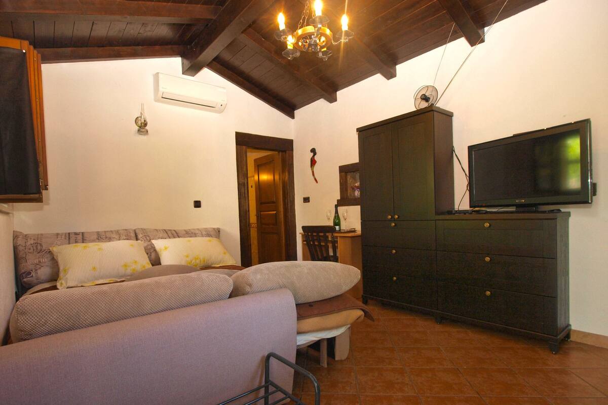 A cozy living room with a sofa, a television, and a cabinet.