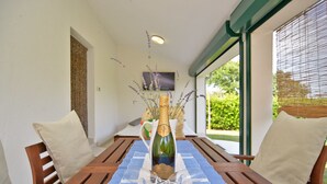 A dining table with a bottle of champagne and two wine glasses on a blue placemat. - House 1666 (Liznjan)