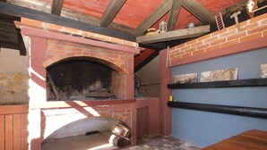 A brick oven with a tiled floor and a wooden table.