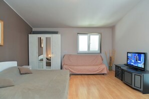 A bedroom with a bed, a wardrobe, a television, and a window. - Apartment 1692 (Fazana)