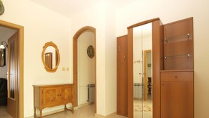 A room with a wooden wardrobe, a mirror, a cabinet, and a patterned rug. - Apartment 1704 (Medulin)