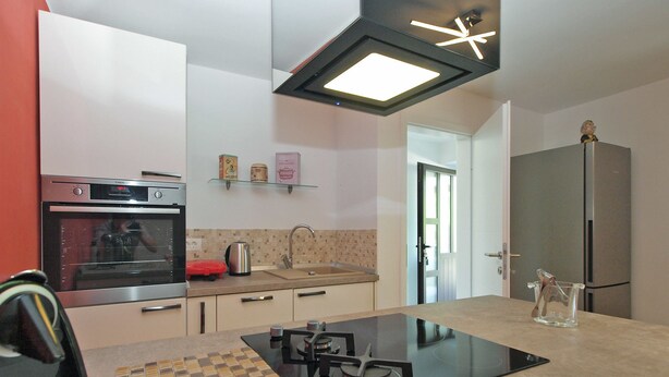 A modern kitchen with a built-in stove, oven, and refrigerator. - House 1708 (Barban)