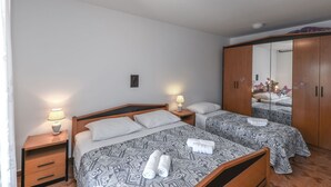 A bedroom with two beds, a wardrobe, and a mirror. - Apartment 1709 (Umag)