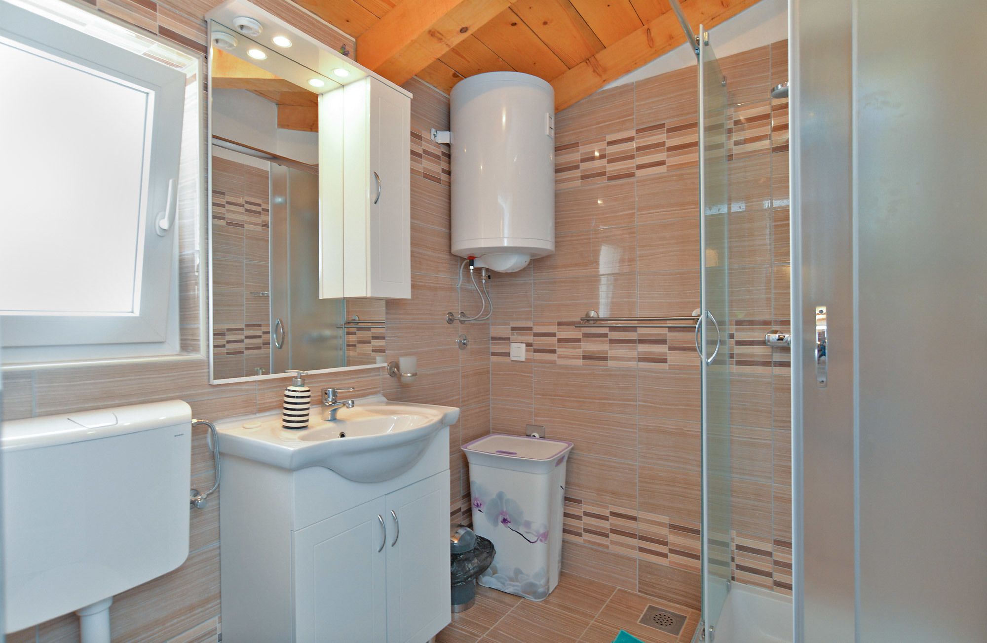 A modern bathroom with a sink, mirror, and toilet.
