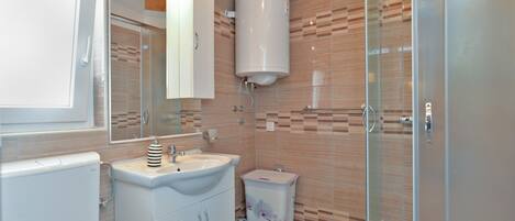A modern bathroom with a sink, mirror, and toilet.