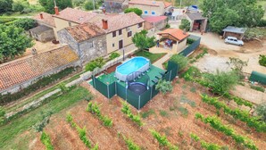 A residential area with a swimming pool, a vineyard, and a small house with a red roof. - House 1735 (Vodnjan)