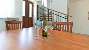 A dining table with a bottle of wine and several glasses. - House 1735 (Vodnjan)