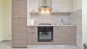 A modern kitchen with a built-in oven, a gas stove, and a stainless steel range hood. - House 1736 (Medulin)