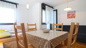 Un comedor con una mesa cubierta por un mantel de lunares, rodeado de sillas de madera.