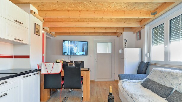 A compact living space with a kitchenette, a dining area, and a sofa. - Apartment 1739 (Medulin)