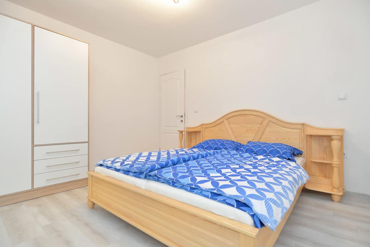 Ein Schlafzimmer mit einem hölzernen Bett, einem Kleiderschrank und einer Tür.