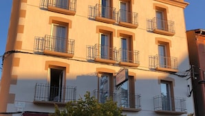 A hotel with multiple balconies, outdoor seating, and a sign indicating it is a hotel. - Hotel Terminus Puigcerdà (Puigcerda)
