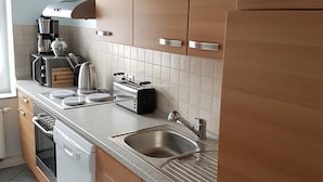 Una cocina moderna con electrodomésticos de acero inoxidable, gabinetes de madera y un salpicadero de azulejos.