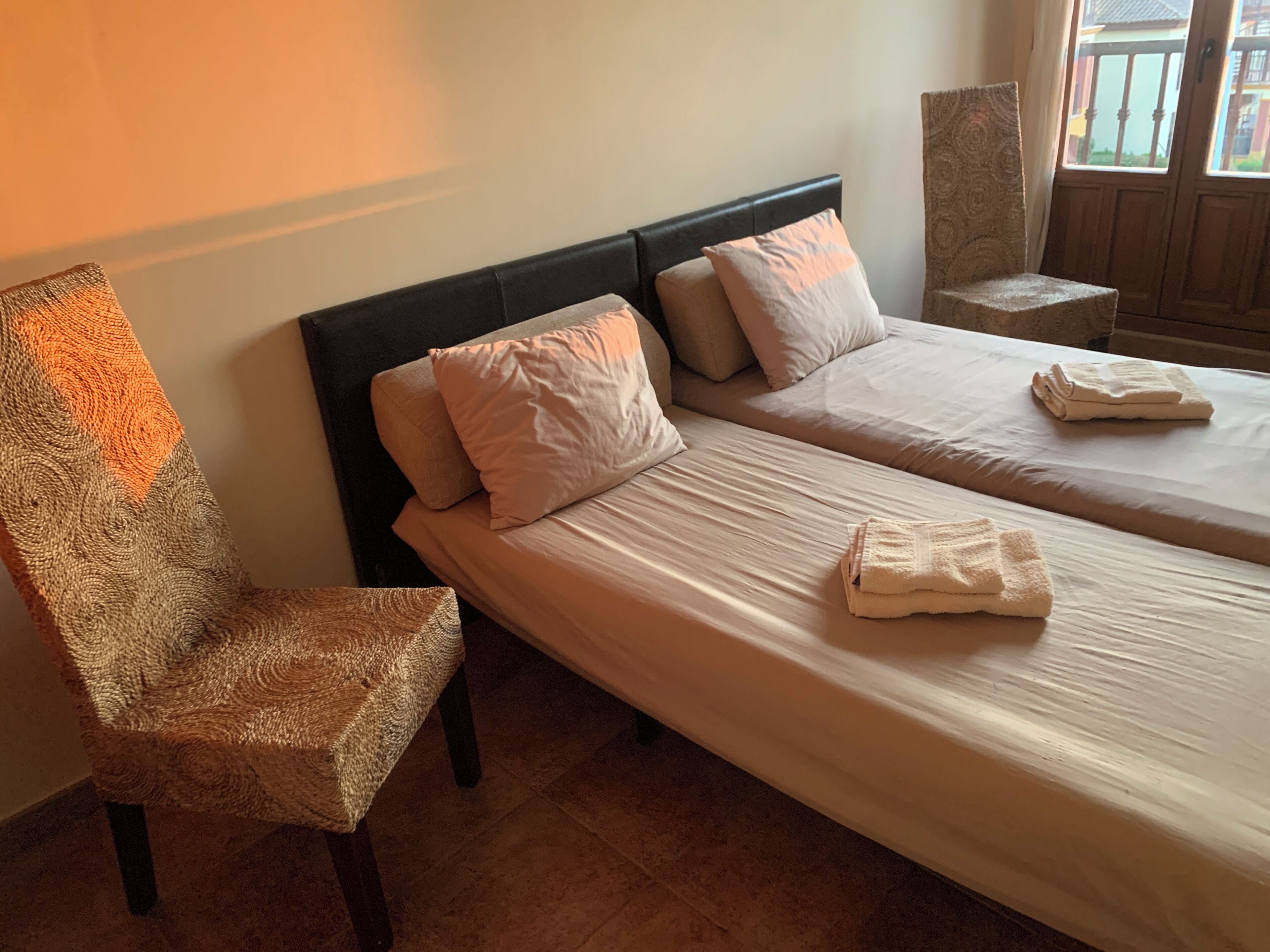 Une chambre d’hôtel avec deux lits, une chaise et une petite table.