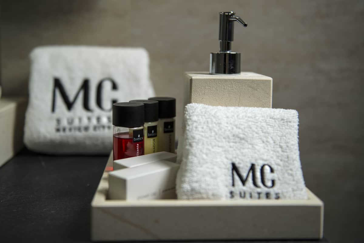 Les équipements d’une chambre d’hôtel comprennent un distributeur de savon, une serviette et des articles de toilette présentés sur un plateau.