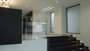 Eine moderne Treppe mit Glastrennwand, minimalistisches Design und eingelassener Beleuchtung.