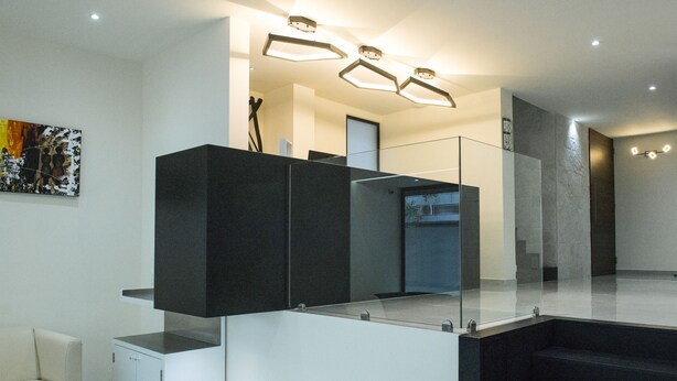 Ein modernes Interieur mit Treppe, Glastrennwand und minimalistischem Design.