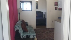 A small, cozy living room with a sofa, a rug, and a window with curtains. - Eva's Place  (Oak View)