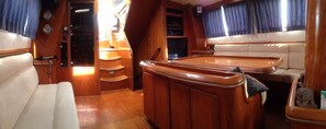 A cabin with a wooden interior, a control panel, a seating area, and a television.