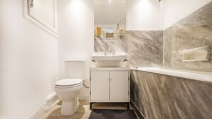 A modern bathroom with a toilet, sink, and mirror. - Acropolis unique view (Athina)