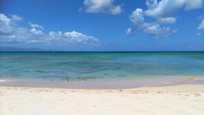 Uma praia com águas turquesa cristalinas e uma faixa de areia.