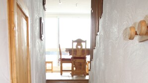 A wooden staircase with red steps leading to a room with a white wall and a wooden door.