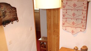 A wooden cabinet with drawers, a hanging lamp, and a wall-mounted decorative piece.