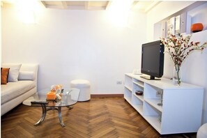 Relax in this stylish living room with a sofa, coffee table, and flat-screen TV.
