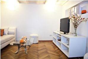 Relax in this stylish living room with a sofa, coffee table, and flat-screen TV.