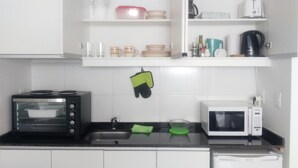 Une cuisine équipée d’un four grille-pain, d’un four à micro-ondes et d’une bouilloire posés sur le plan de travail.