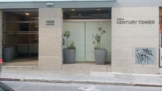 L’entrée de l’hôtel Century Tower, qui présente un design moderne, est agrémentée de grands pots de plantes et d’une enseigne bien visible indiquant l’adresse : 1435.