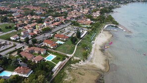 Vista aérea de una zona residencial costera con casas, una playa y un puerto deportivo.
