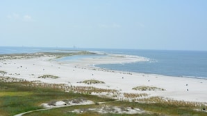 A coastal landscape with sandy beaches and a clear sky. - Best seat in the house! FALL RATES, NO CROWDS, RENT A GOLF CART, WALK THE BEACH. (Dauphin Island)