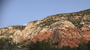 Una montaña con superficie rocosa y vegetación escasa.