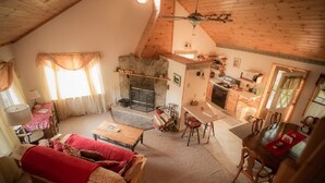Een gezellige loft met een woonkamer, een open haard, een eethoek en een keuken.