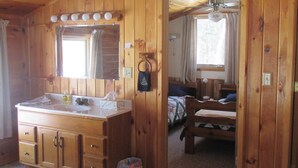 Een houten chalet inrichting met een grote houten kaptafel, een bed en een klein tafeltje.