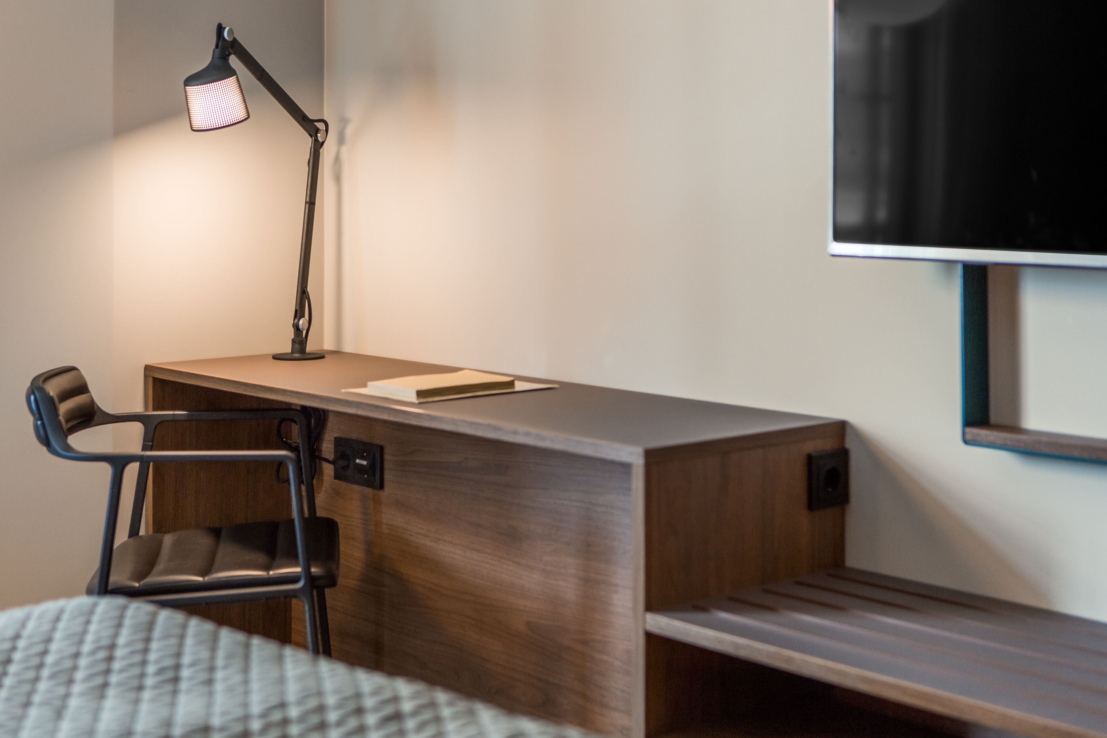 Una habitación moderna con escritorio, silla y cama.