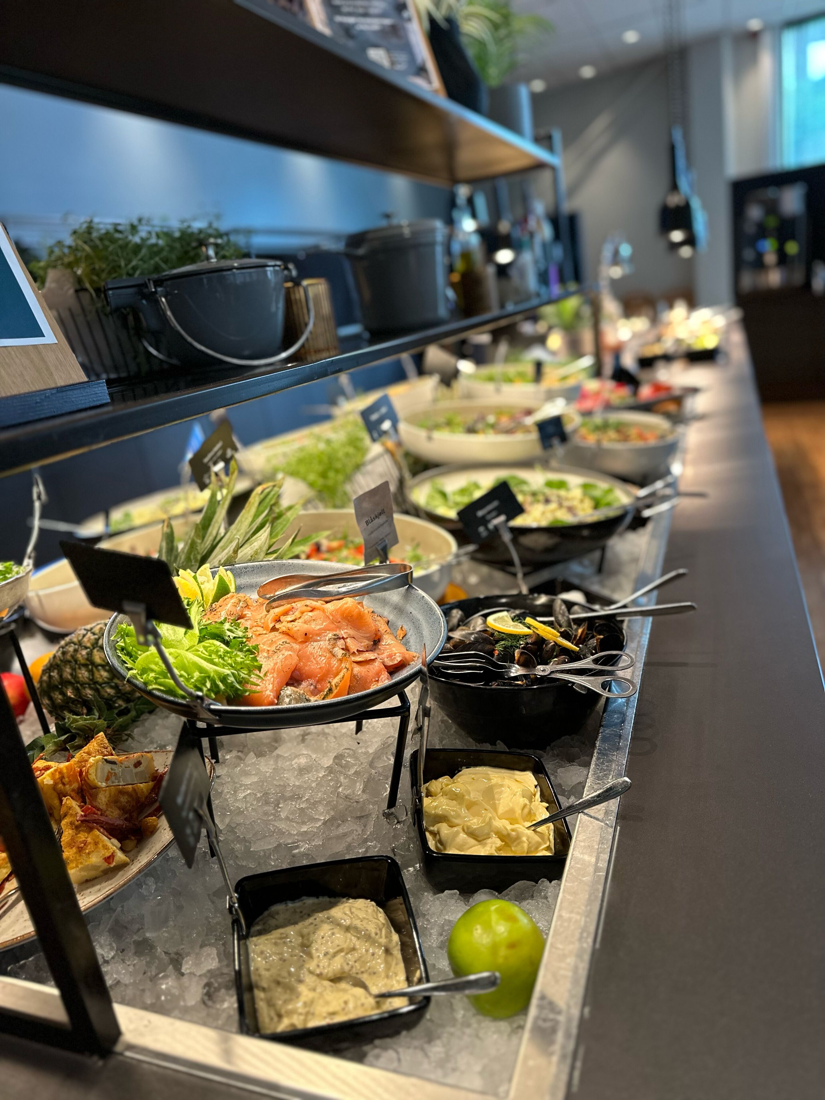 A buffet with various dishes, including seafood, salads, and dips, served on ice.