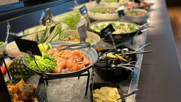 A buffet with various dishes, including seafood, salads, and dips, served on ice.