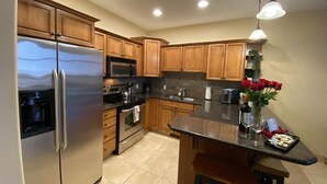 Una cocina moderna con armarios de madera, electrodomésticos de acero inoxidable y una isla central.