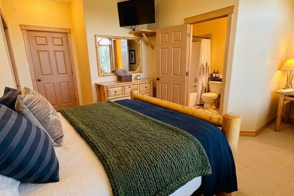 Master Bedroom with custom log Queen Bed, TV, Cable and s Desk (just in case you need to do some work?).