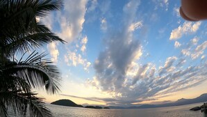 Mar tranquila con cielo despejado y montañas a lo lejos.