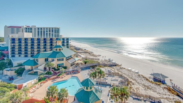 Un hotel con piscina, acceso a la playa y vistas al océano.