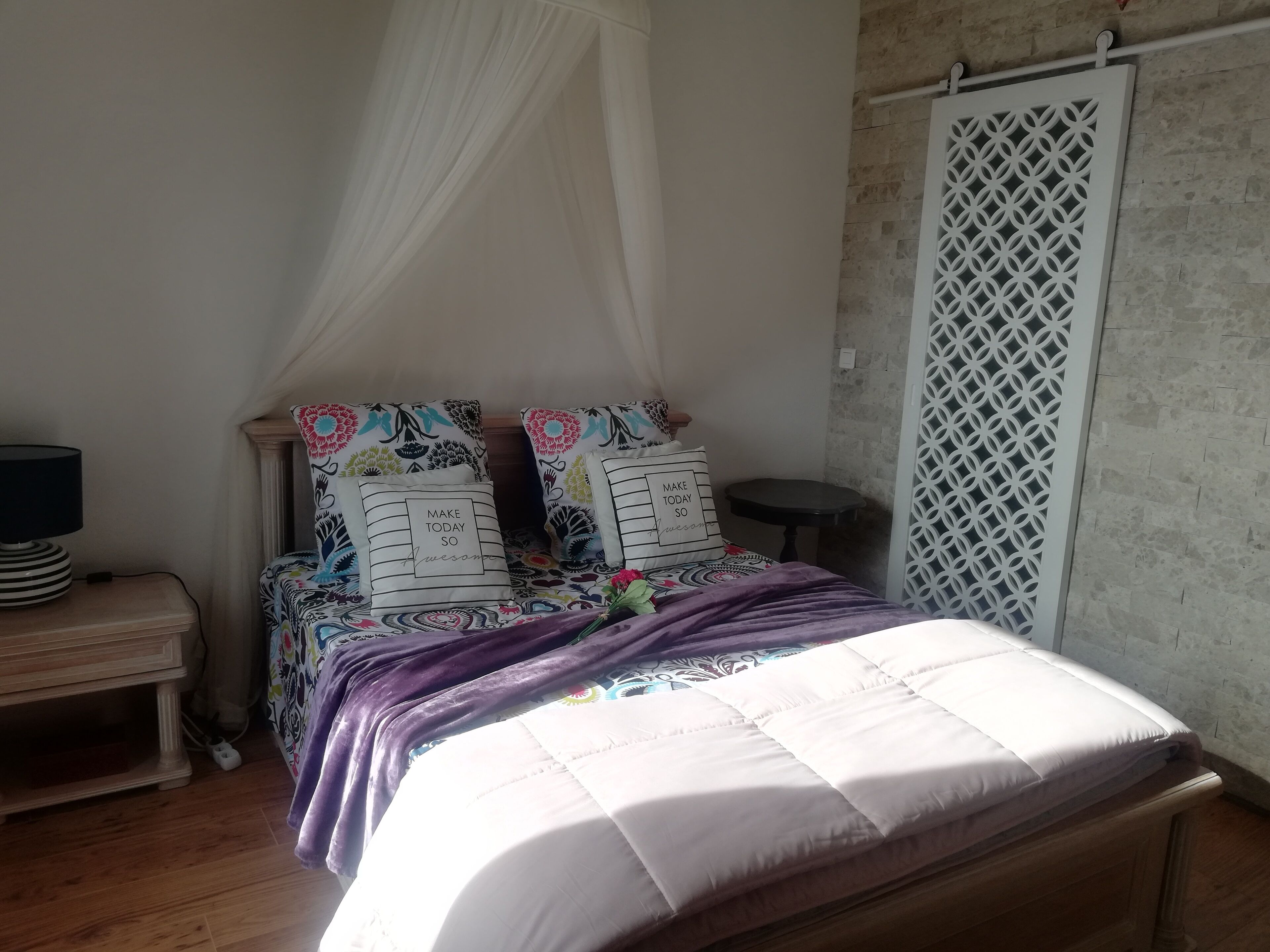 Een slaapkamer met een bed, nachtkastje en een bijpassende tafel.