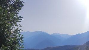 Un mur de pierre avec une terrasse en bois donnant sur un paysage montagneux.