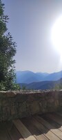 Un muro de piedra con un muelle de madera que da a un paisaje montañoso.