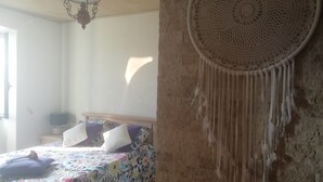 Une chambre à coucher avec un lit, une décoration murale et un luminaire suspendu.