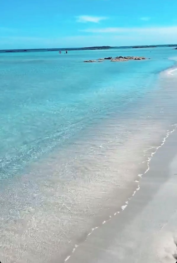 Ein Strand mit klarem türkisblauem Wasser und einem sandigen Ufer.