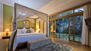 Quarto com cama de dossel, uma janela grande com vista para plantas tropicais e um tapete aconchegante.